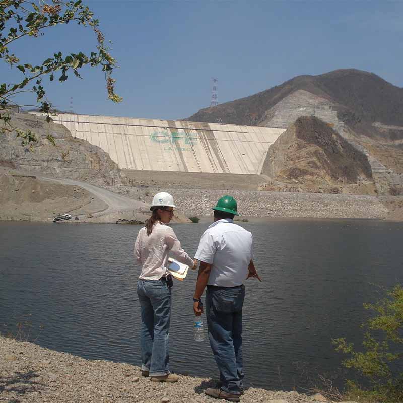 Profesionales supervisando el desarrollo de proyectos en una represa, brindando servicios especializados en ingeniería hidráulica y ambiental.