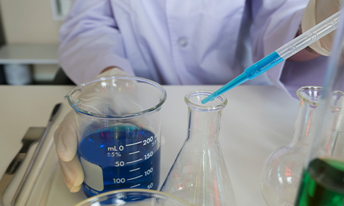 Técnico realizando análisis de agua en laboratorio, parte de los estudios ambientales para evaluar la calidad del agua y asegurar el cumplimiento normativo.